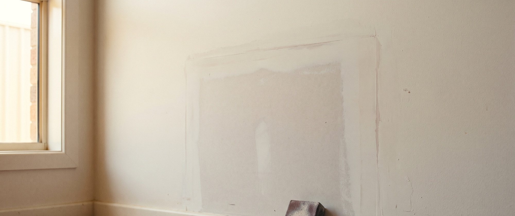 A patched section of wall sanded back and waiting for paint