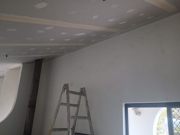 A set wall beside a window with a ladder resting against it