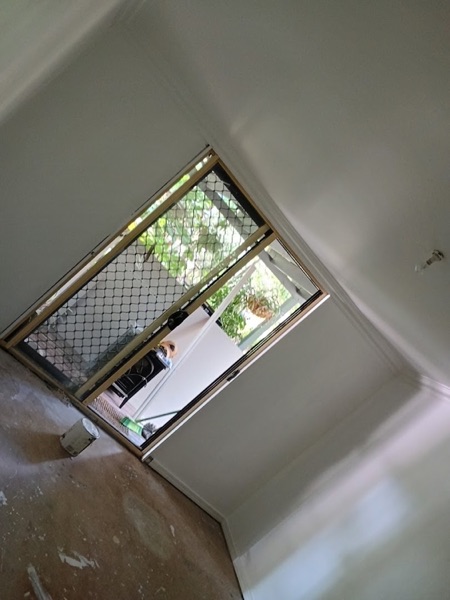 A window with a security screen set into a freshly plastered wall