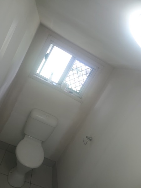 A bathroom window above a set and sanded wall