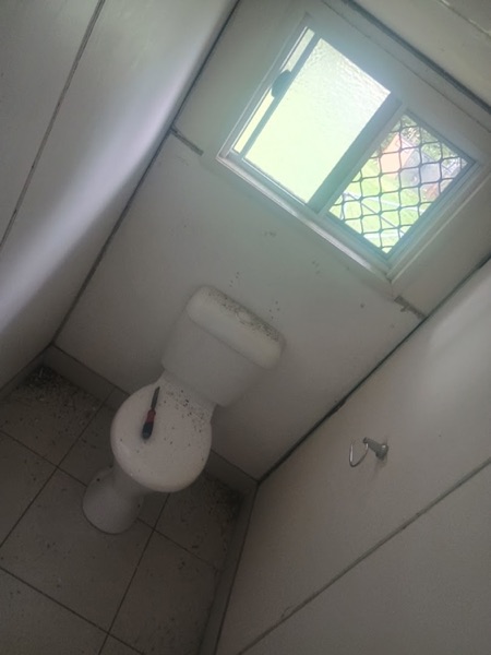 A small bathroom with the walls patched around the fittings