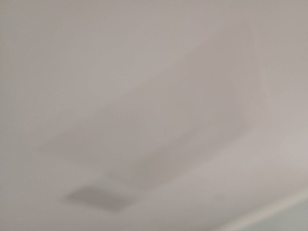 A finished plastered wall meeting the ceiling in a corner of a room