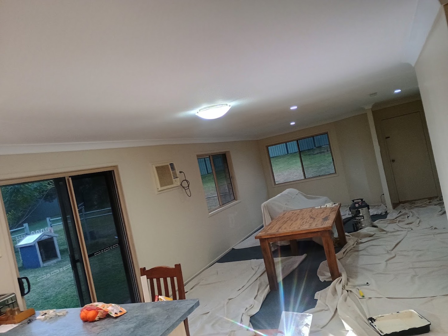 A finished lounge room with drop sheets still down after plastering and painting